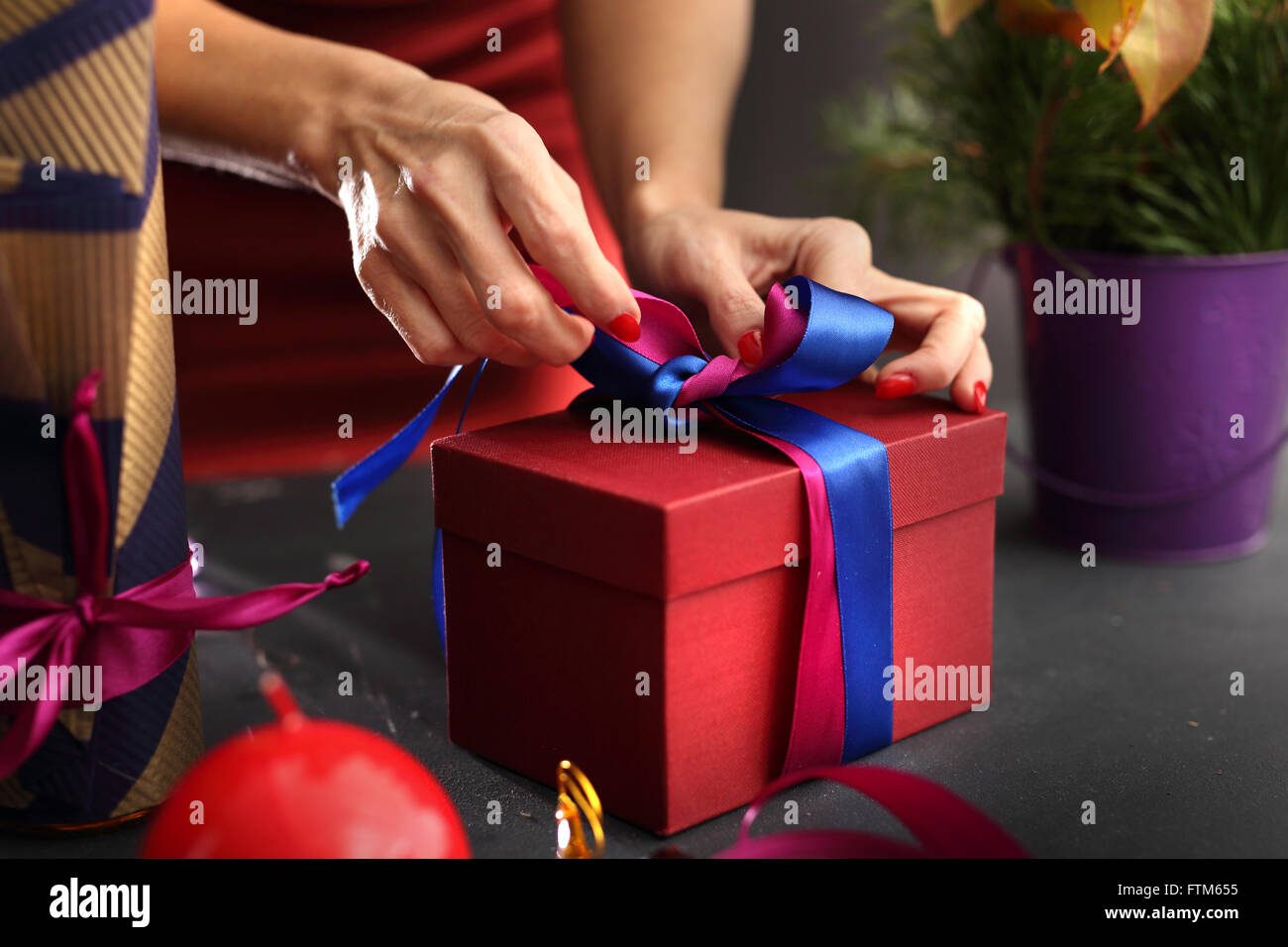 Gift wrapping. Christmas gift idea how to decorate a gift. Beautifully wrapped gift. Stock Photo