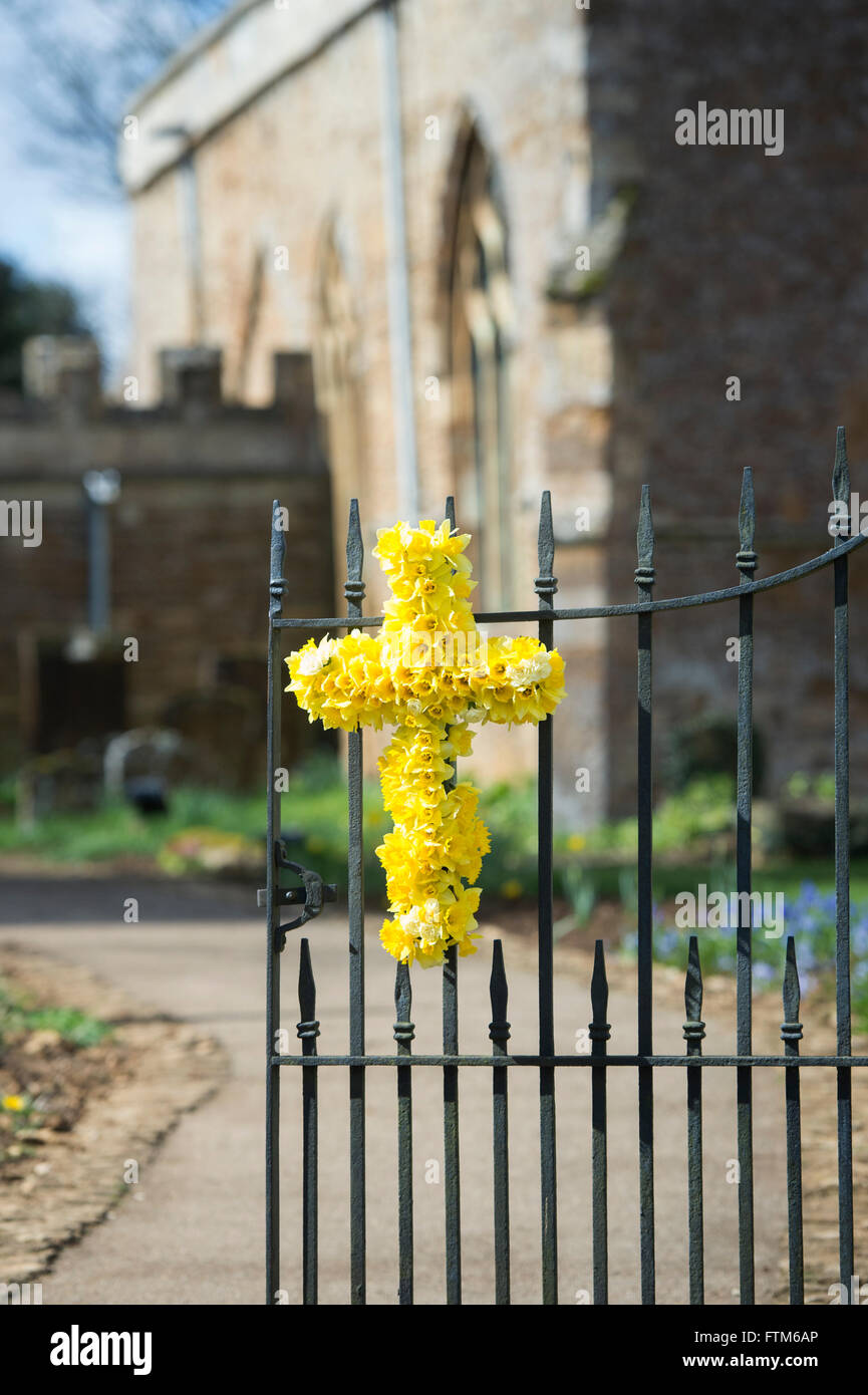 Easter Daffodil cross on the gates of St Peter & St Paul church. Kings Sutton, Banbury, Northamptonshire, England Stock Photo