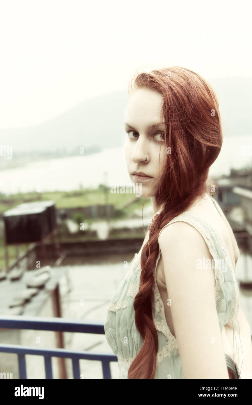 Portrait of beautiful young woman with long red hair, outdoors Stock Photo