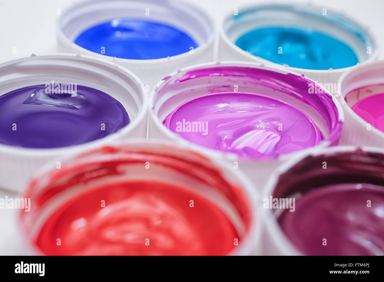 Colorful acrylic paints in covers isolated on table Stock Photo