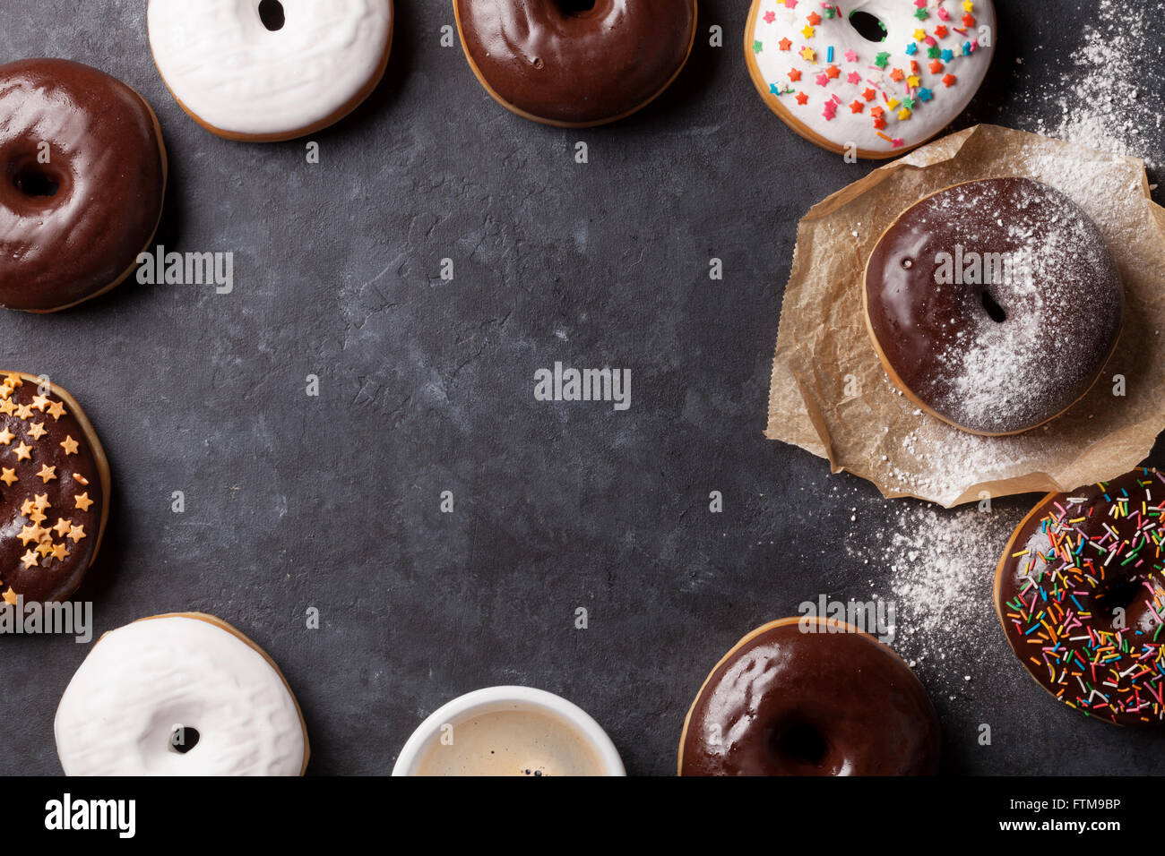 Colorful donuts and coffee on stone table. Top view with copy space ...