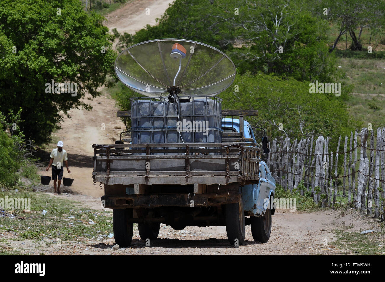 Parabolic antenna being transported in a rural town Stock Photo