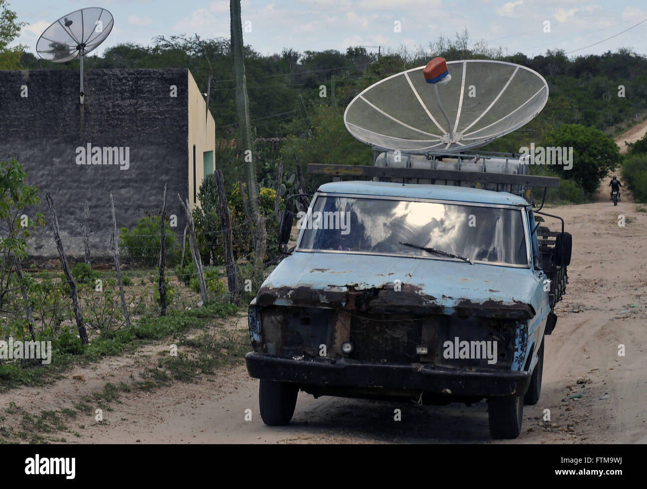 Parabolic antenna being transported in a rural town Stock Photo