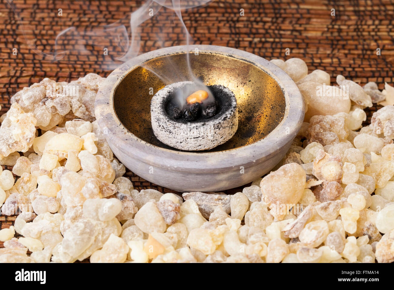 Frankincense burning on a hot coal. Frankincense is an aromatic resin, used for religious rites, incense and perfumes. Stock Photo