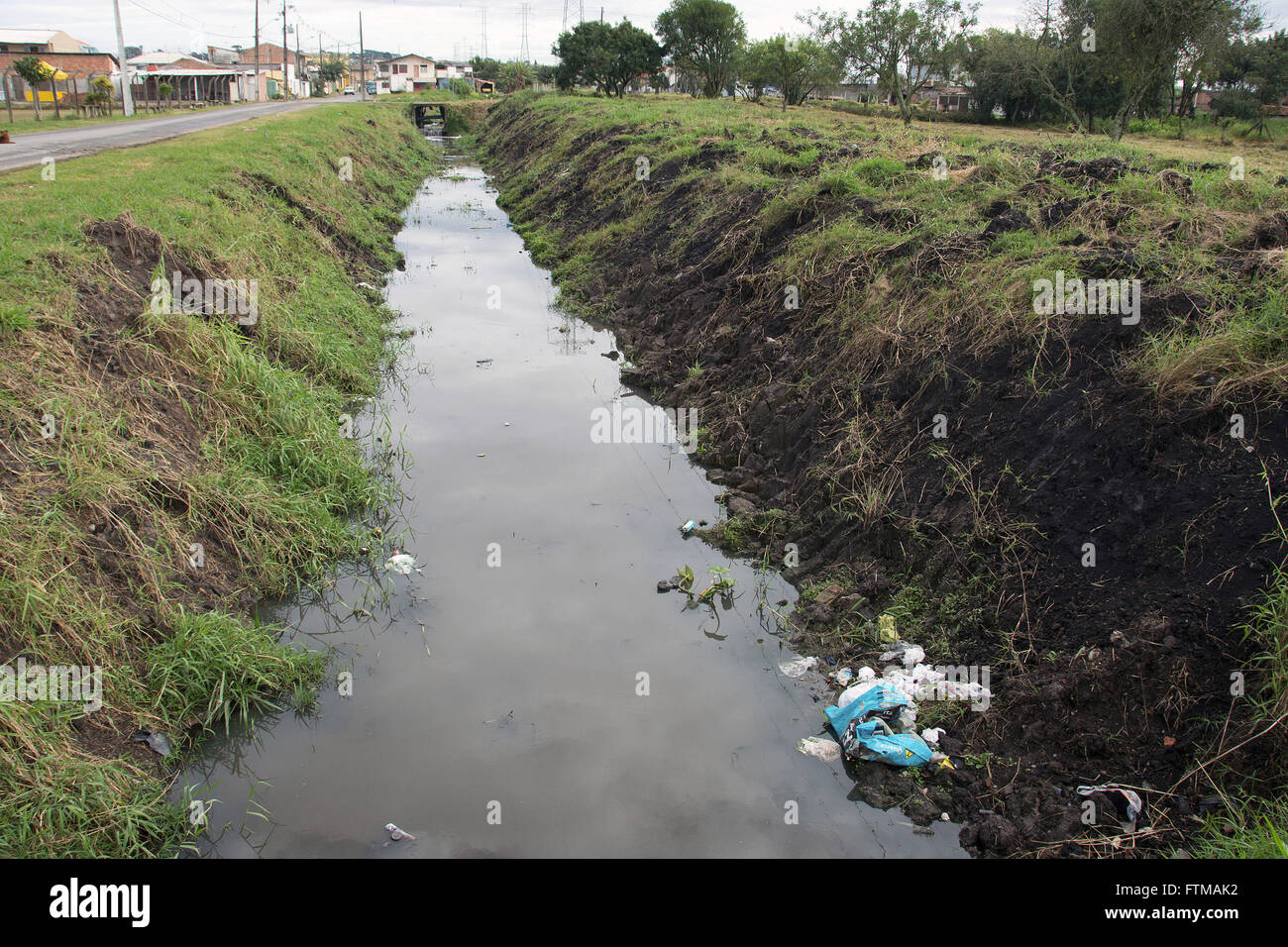 Trash on the edge of the River Iguacu rectified channel change intervention of the river course Stock Photo