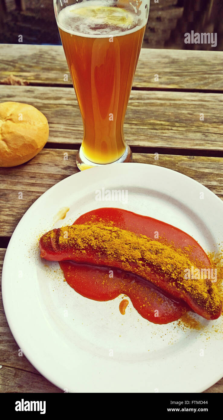 Bavarian beer garden food, curry wurst with bread and beer on grunge wooden table Stock Photo