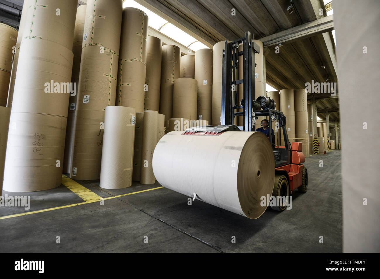 Worker carrying recycled paper roll forklift Stock Photo