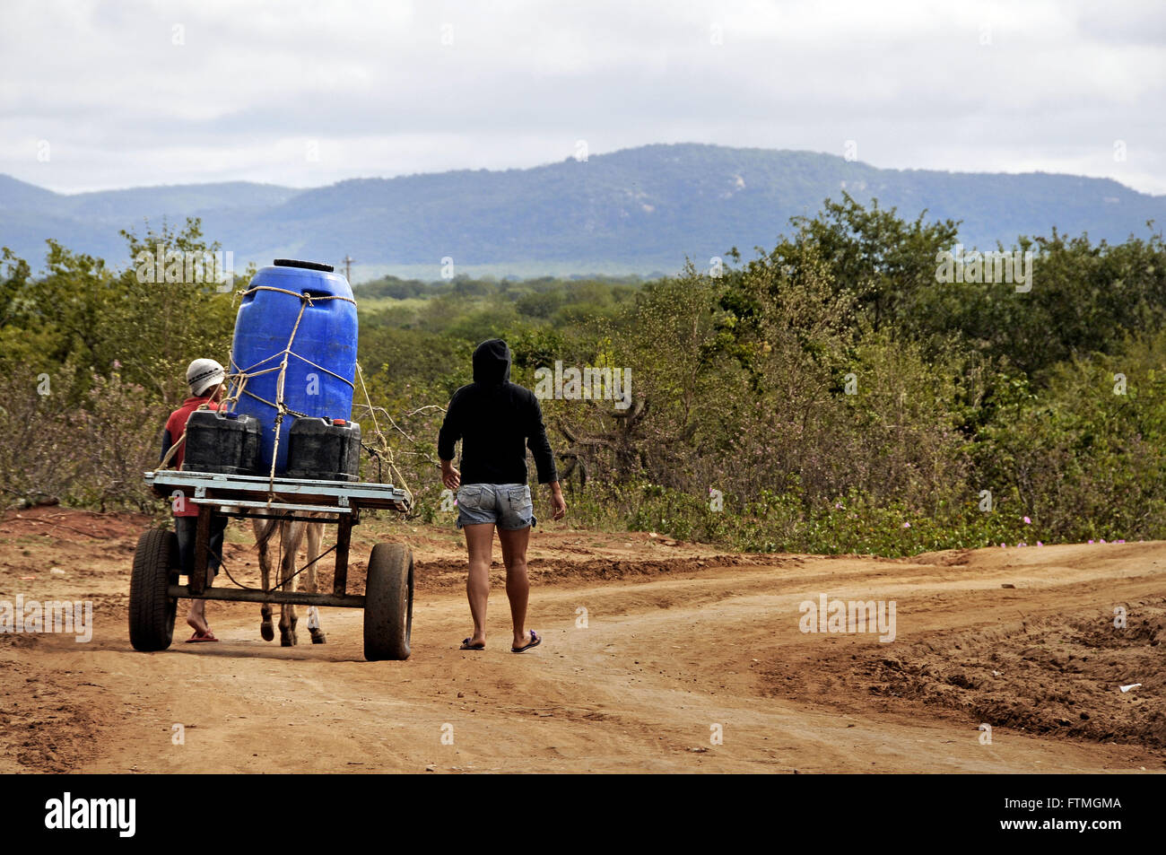 Small farmer carrying water in the rural town of Sertania Stock Photo