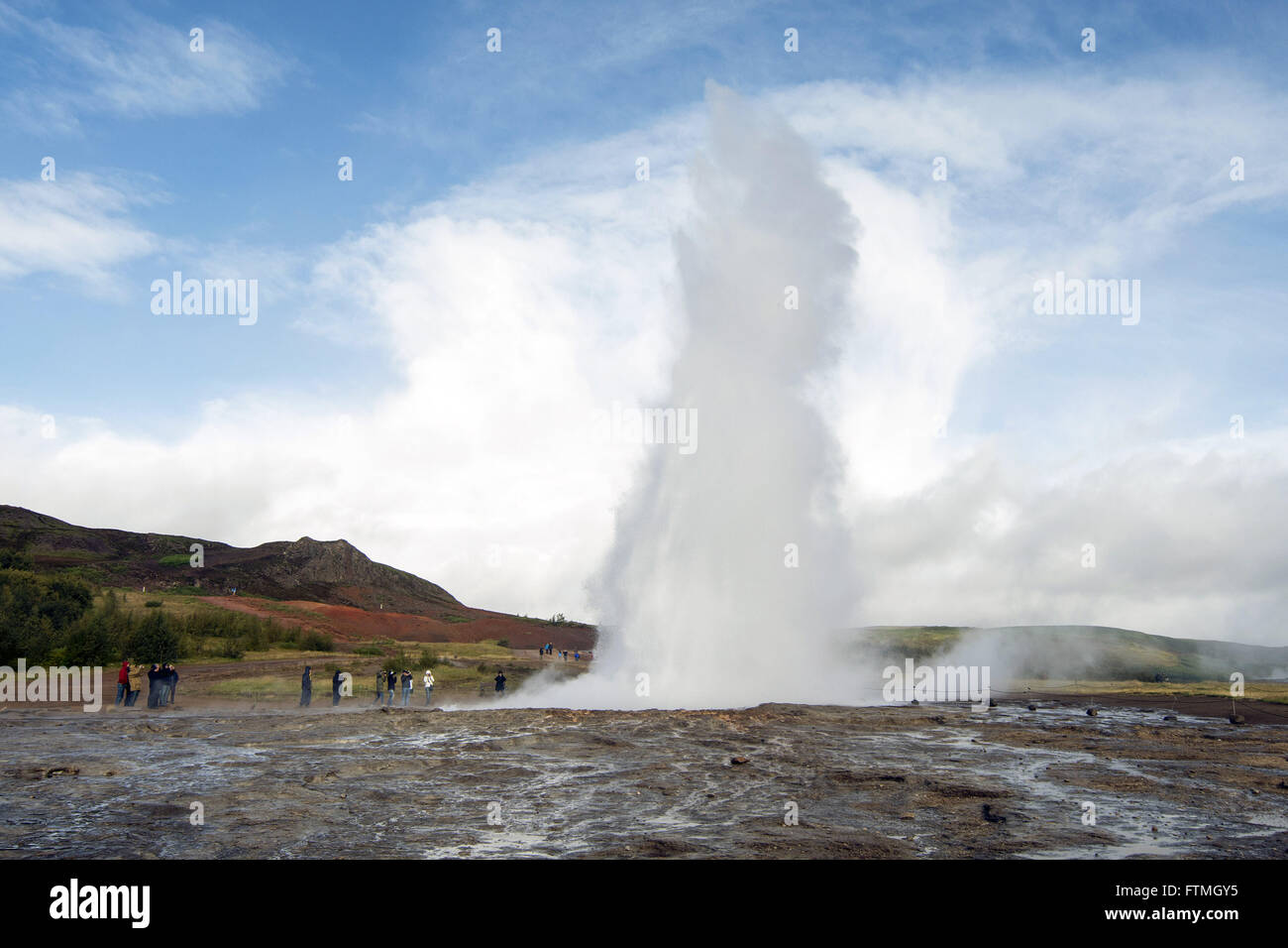 Tourists in the geothermal region of Geysir geyser named geological phenomenon Stock Photo