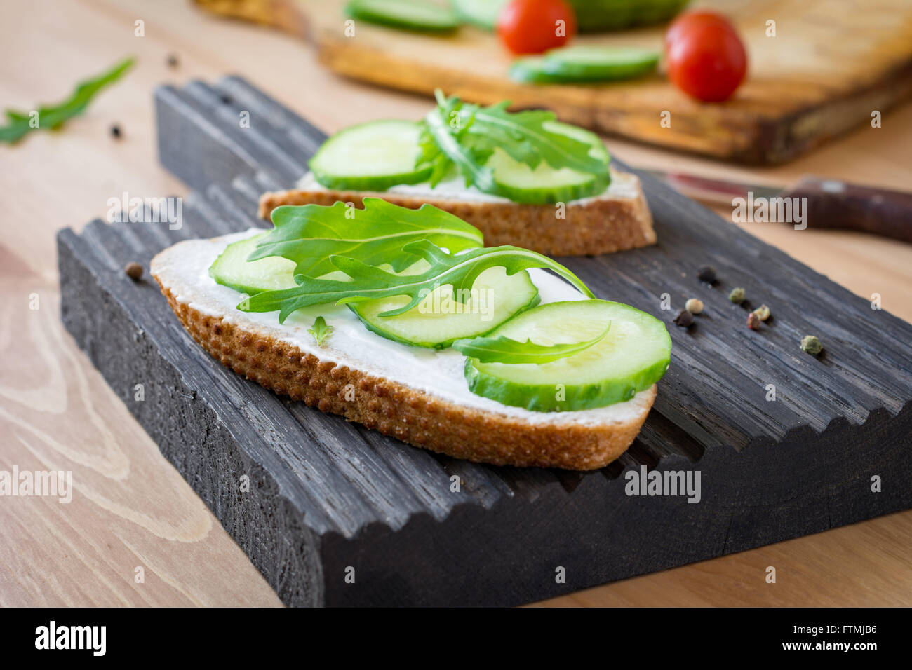 Healthy breakfast or snack Cucumber, cream cheese and arugula toast on