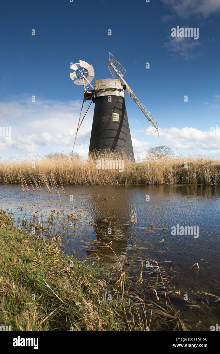 Mutton's Drainage Mill stands on the edge of a waterway at Halvergate Marshes along the Norfolk Broads, East Anglia, England, UK Stock Photo