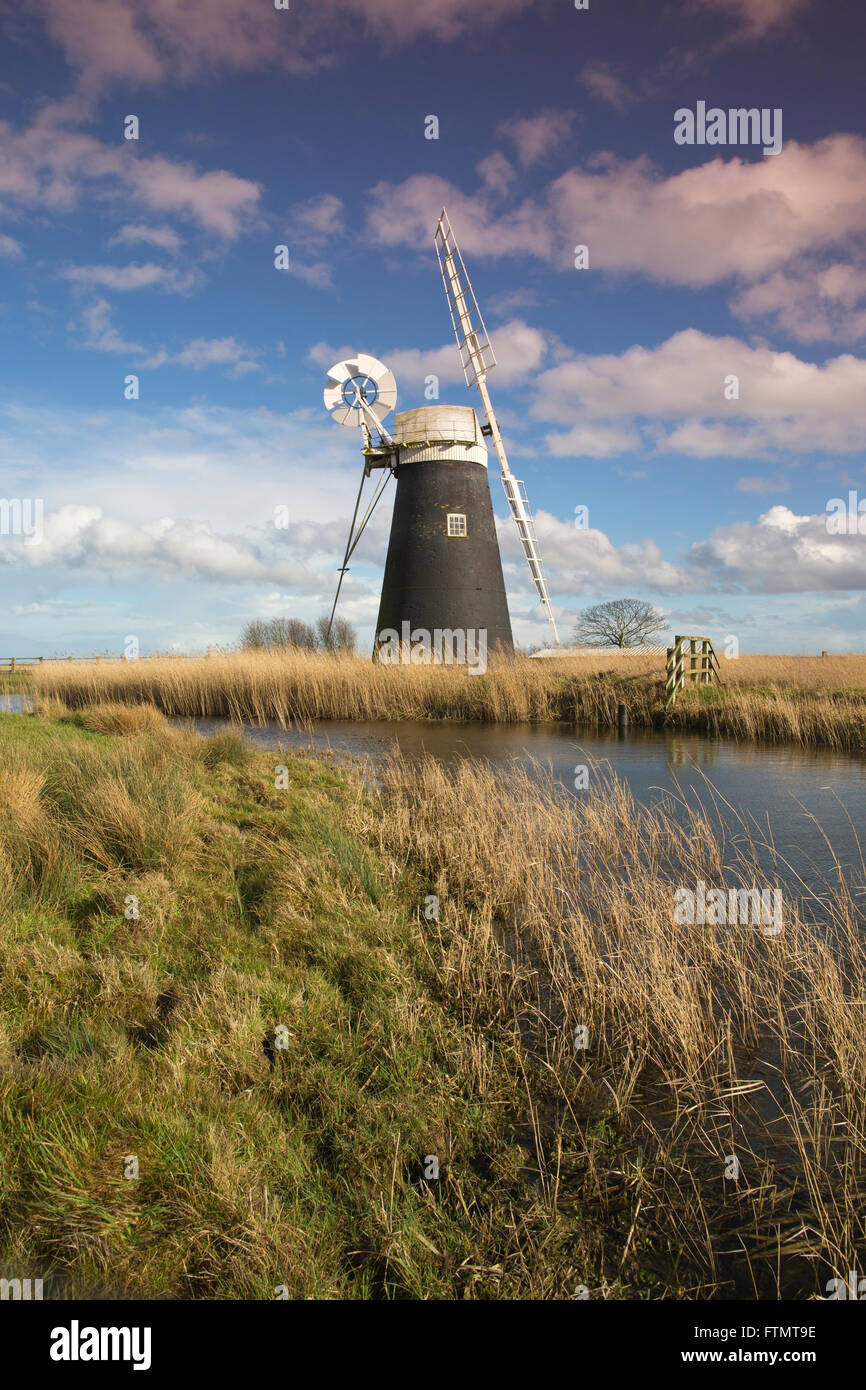 Mutton's Drainage Mill stands on the edge of a waterway at Halvergate Marshes along the Norfolk Broads, East Anglia, England, UK Stock Photo
