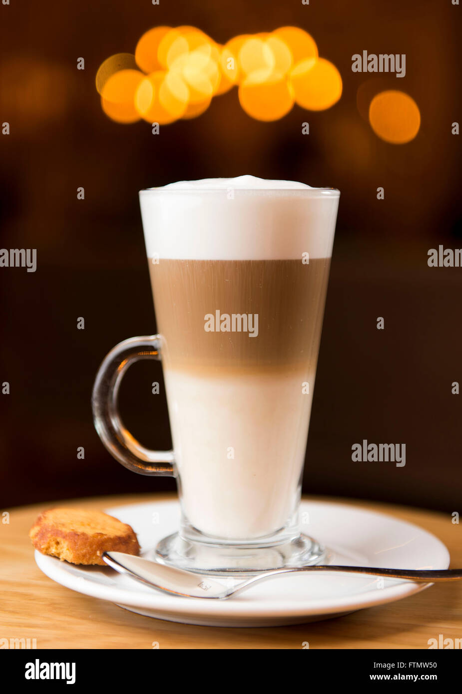 A tall glass off latte coffee in a coffee shop bar. Stock Photo