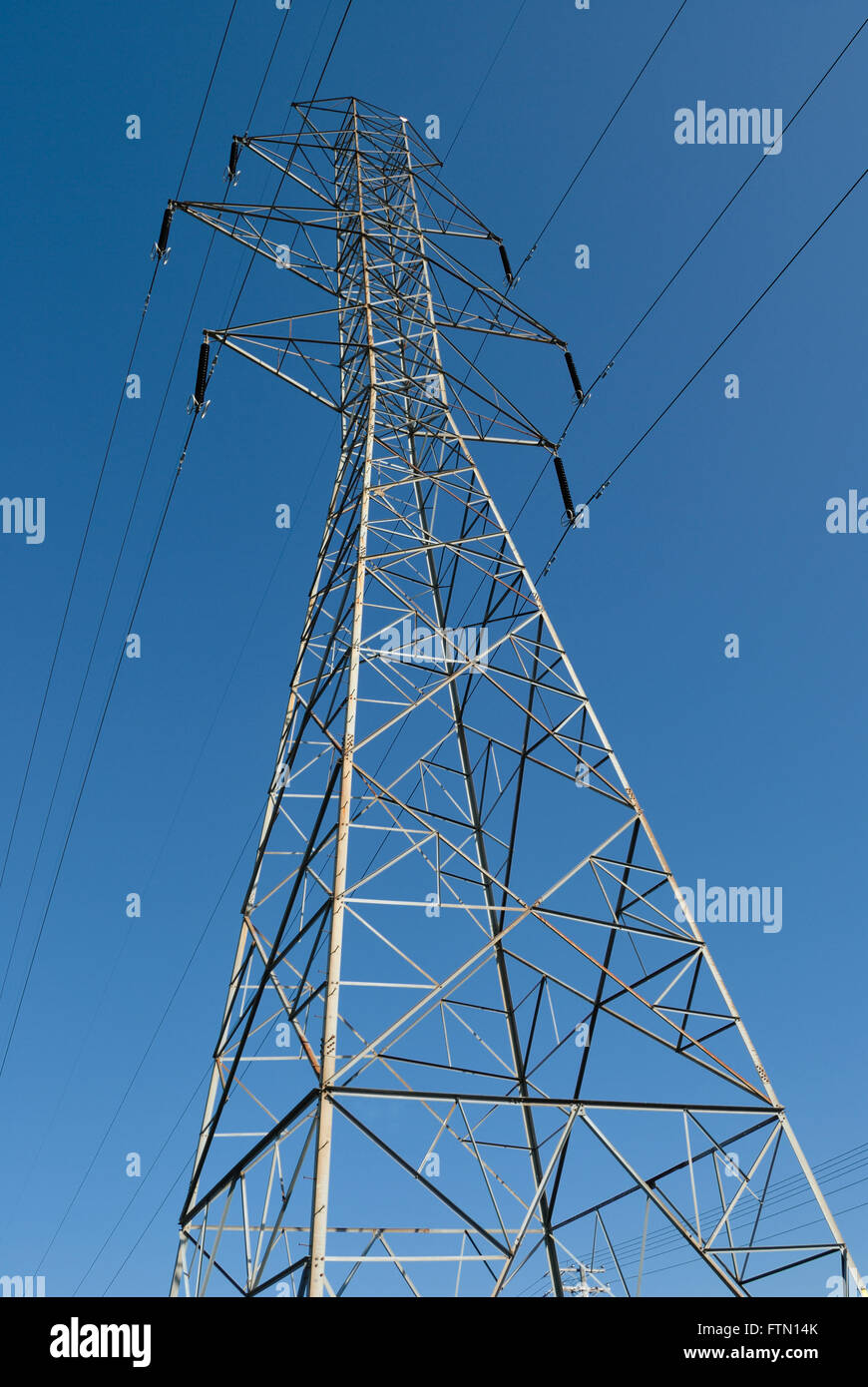 High Voltage Transmission Tower against a blue sky Stock Photo - Alamy