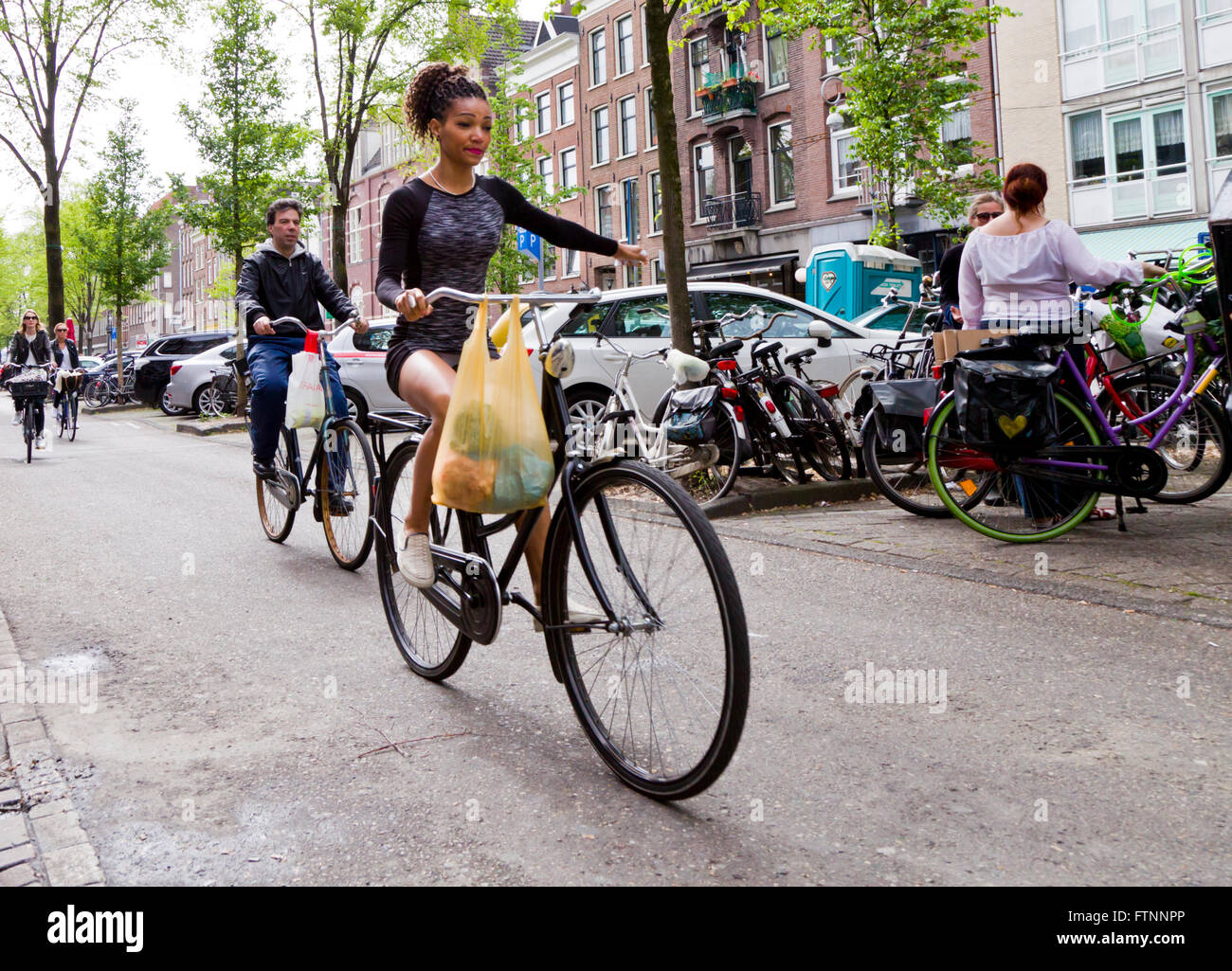 Young woman riding a bike in Amsterdam Stock Photo Alamy
