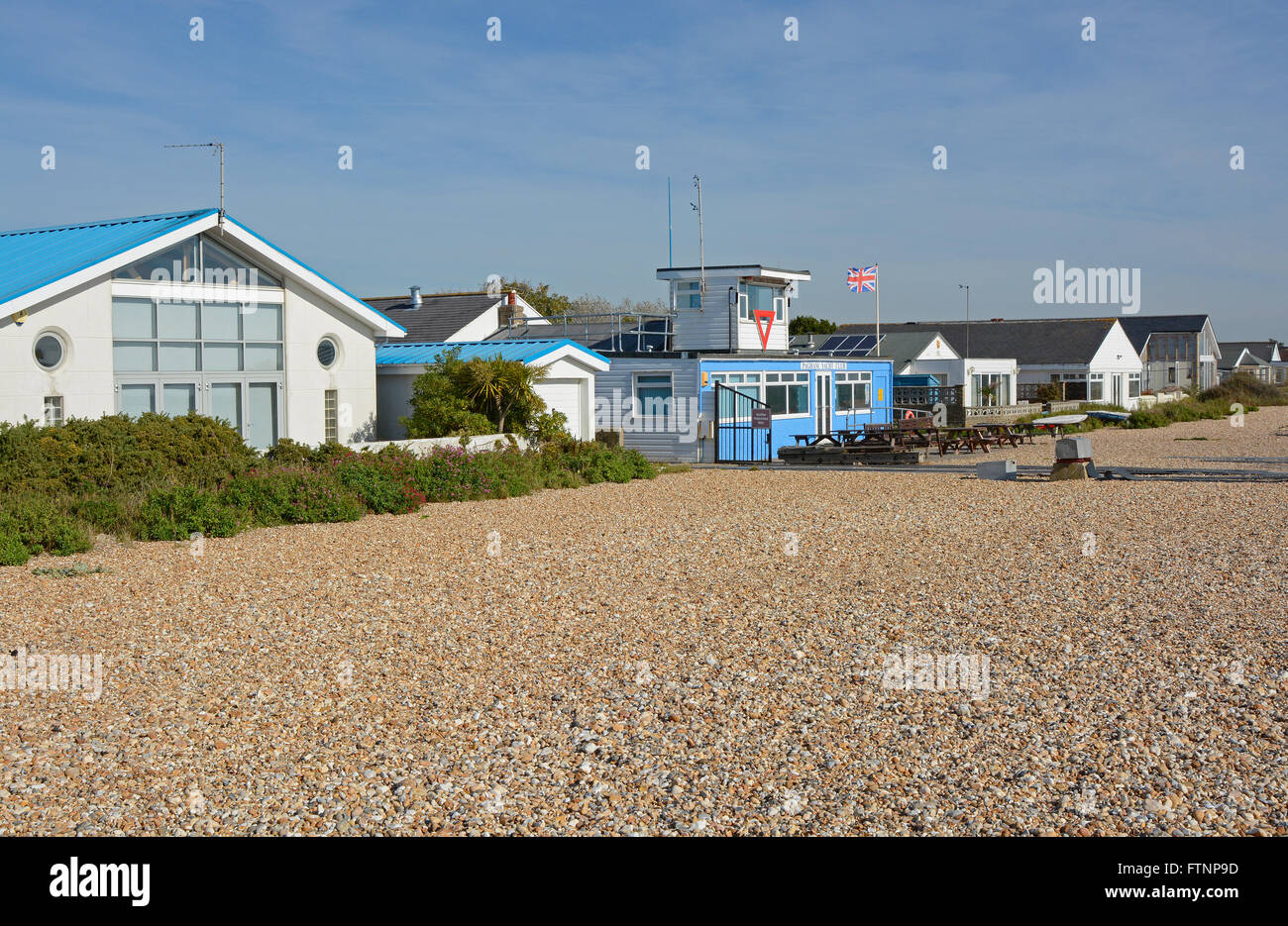 Homes and sailing club on the shingle beach at Pagham in West Sussex