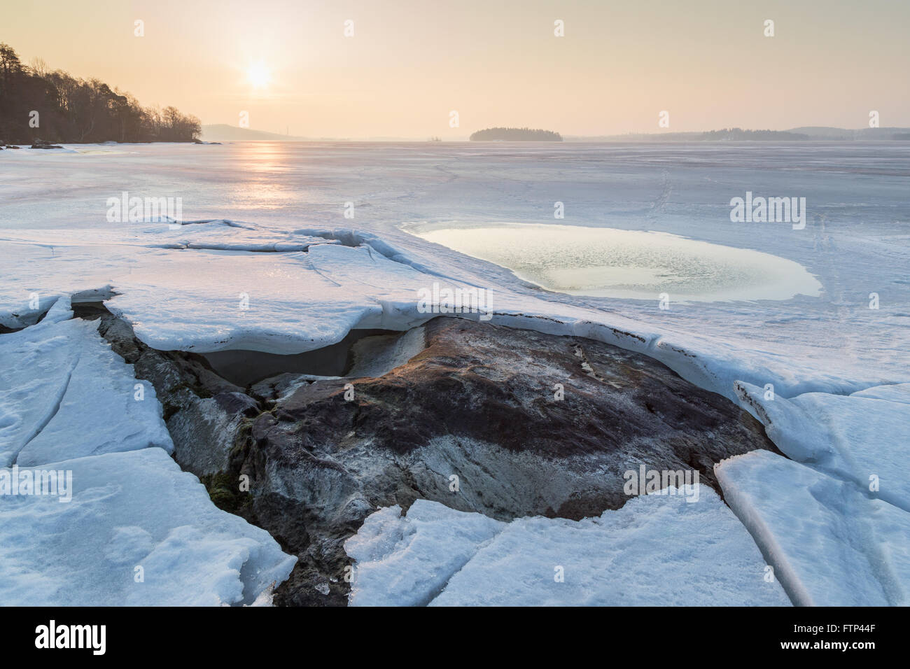 Rock Under Cracked Ice At A Frozen Lake In Finland In The Spring At Stock Photo Alamy
