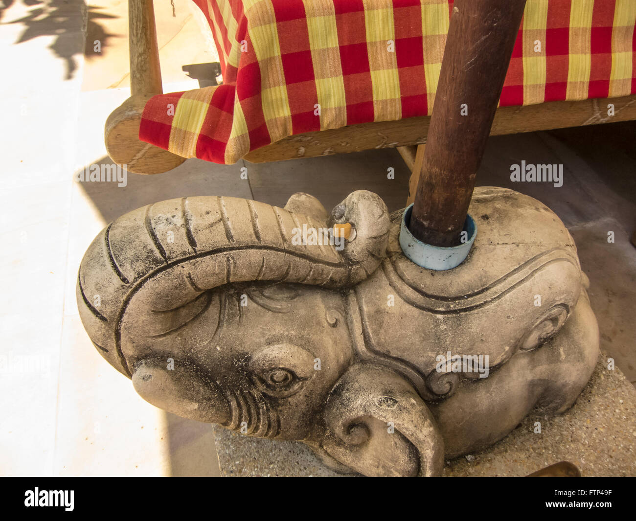Cigarette smokers, what can I use as an ash tray in this no smoking area. Cigarette butt extinguished on an ornamental elephant. Stock Photo