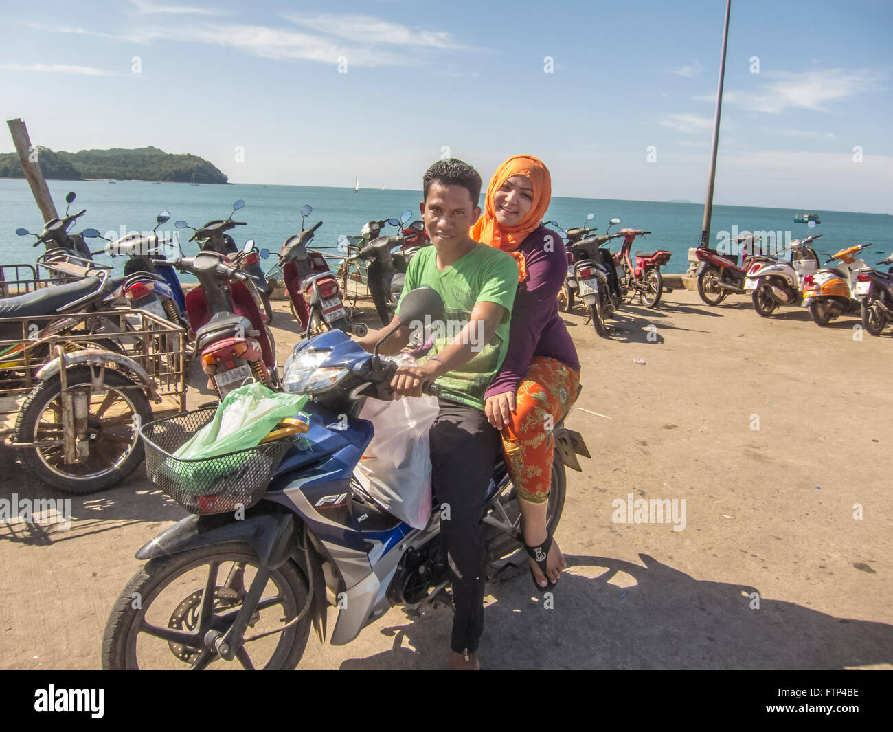 Local couple, man and woman, on their motorbike on Chong Lad Pier. Koh Yao Yai island. Thailand Stock Photo