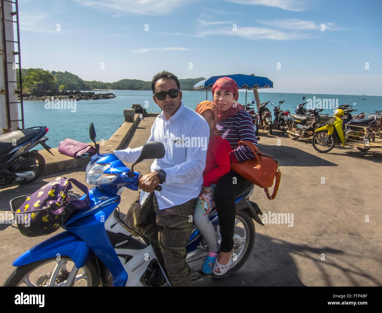 Local family, mum dad and daughter out on their motor bike. Koh Yao Yai island. Thailand Stock Photo