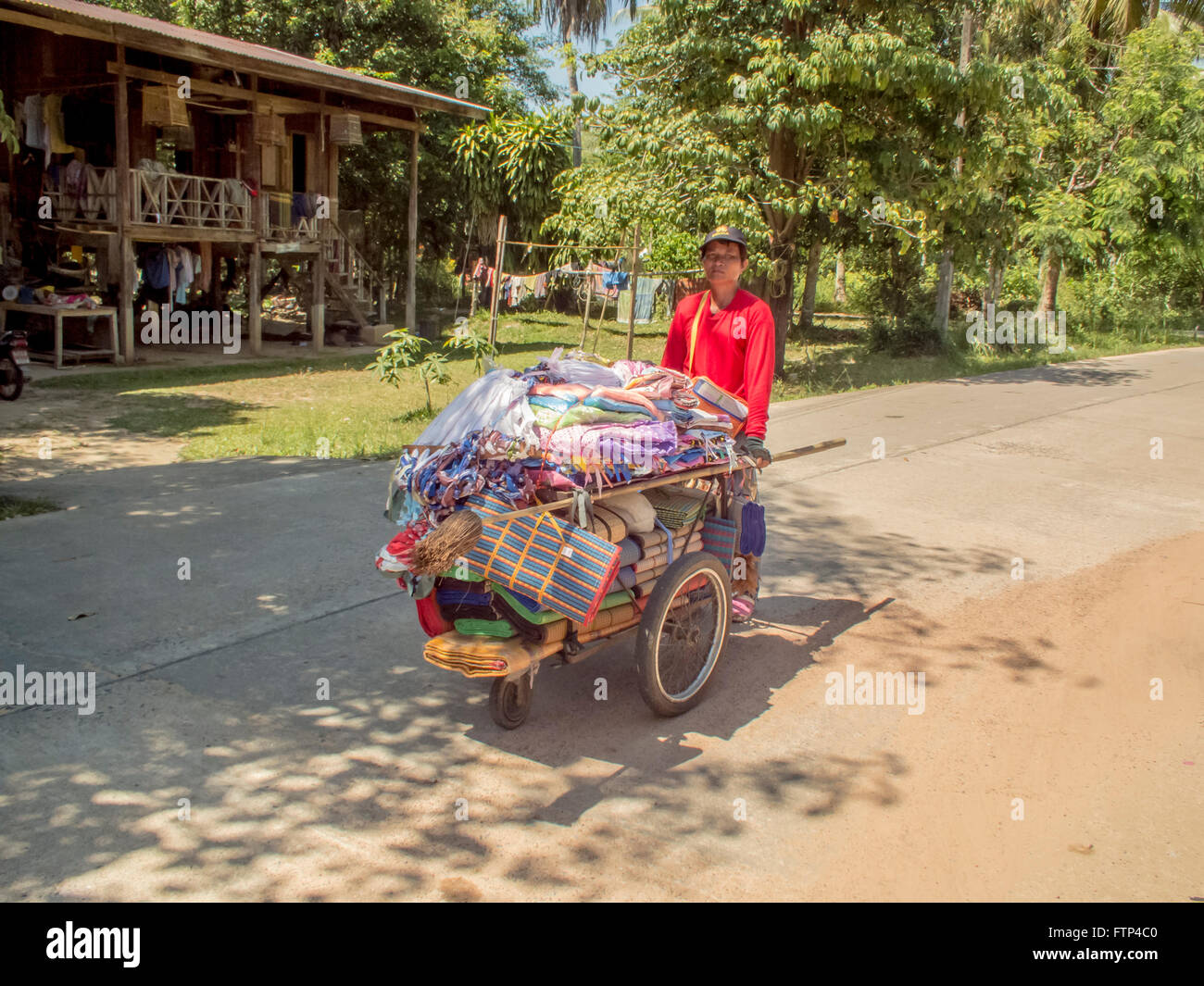 Kho Yao Yai island local traders selling their wares. local man sells mats and fabric from his barrow. Stock Photo