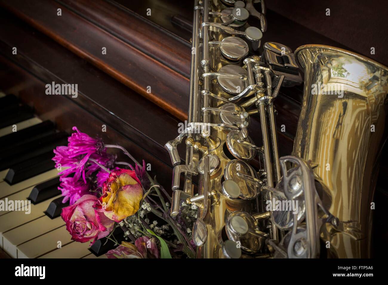 Old and worn Jazz saxophone and piano with dried roses Stock Photo - Alamy