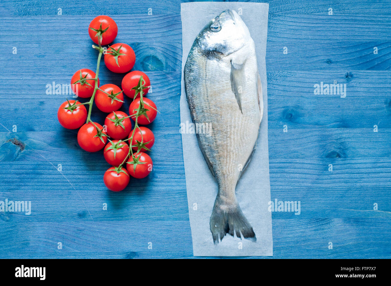 Fish bream cooked in crazy water, typical recipe of southern Italy with sea water, tomatoes, onions and garlic,italy Stock Photo