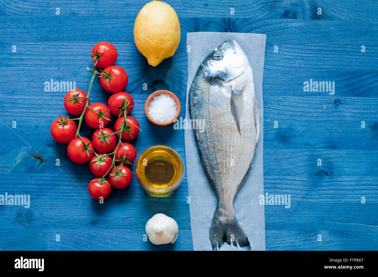 Fish bream cooked in crazy water, typical recipe of southern Italy with sea water, tomatoes, onions and garlic,italy Stock Photo