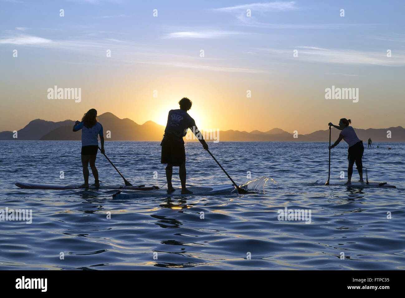 Pratica de SUP Stand Up Paddle na Praia de Copacabana ao amanhecer - zona sul Stock Photo
