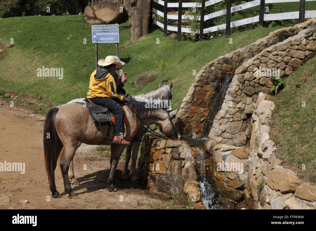 Riders and horses chatting drinking water in District Storeroom in the countryside Stock Photo