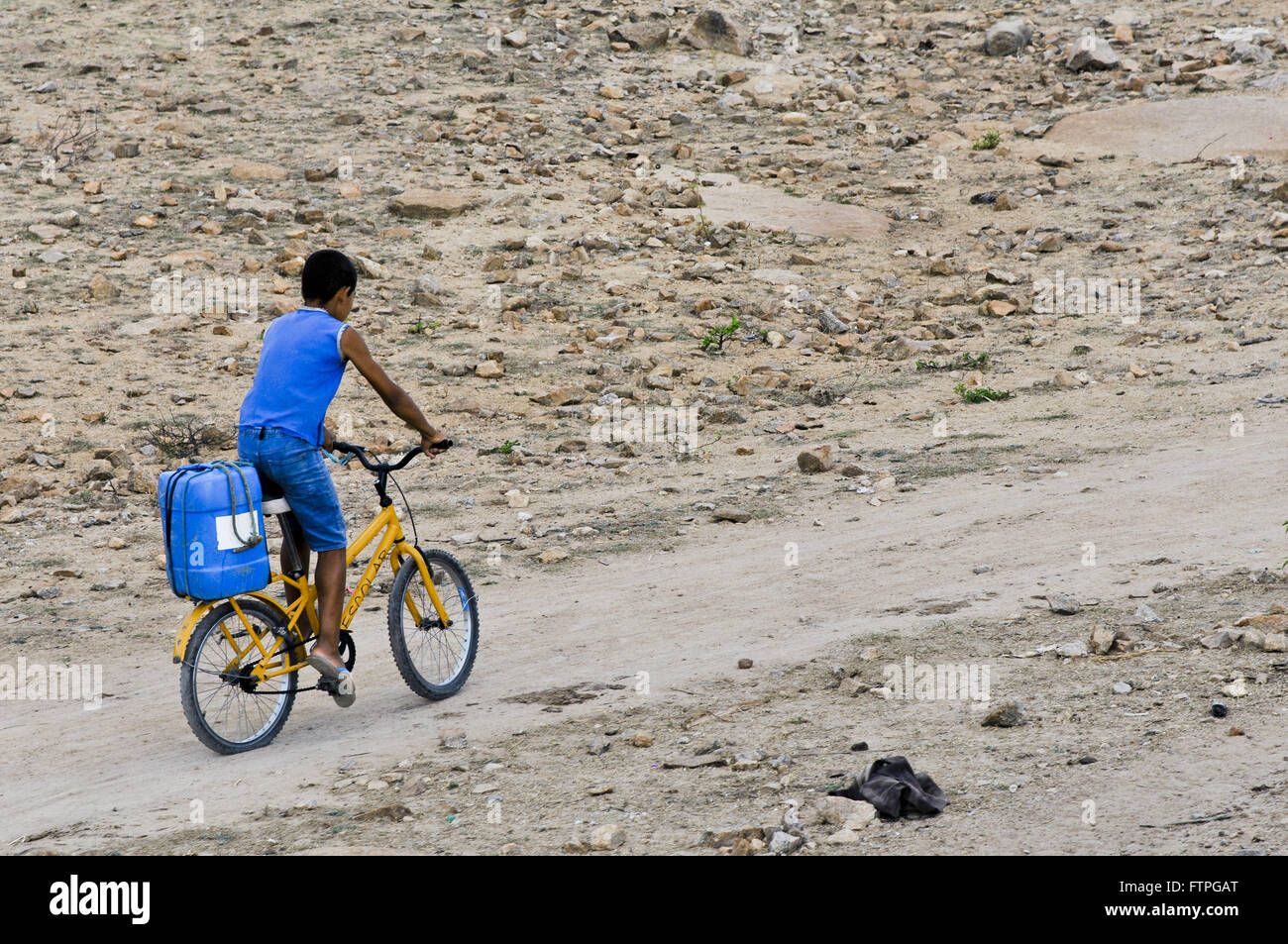 Boy Loading gallon with water cycling in rural populated Mulungu Stock Photo