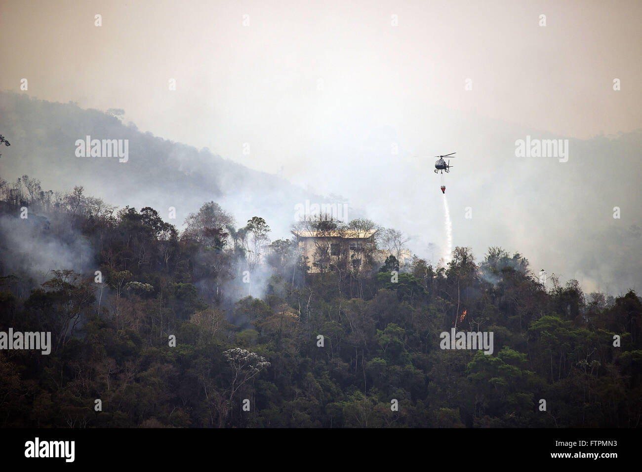 Firemen equipped helicopter to fight fire Stock Photo