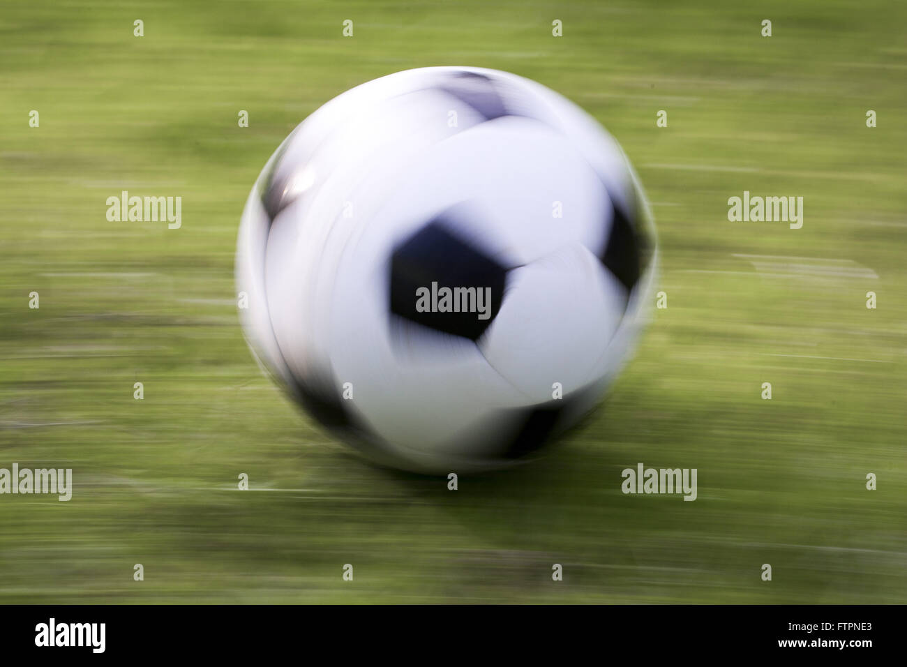 Soccer ball in motion on lawn Stock Photo