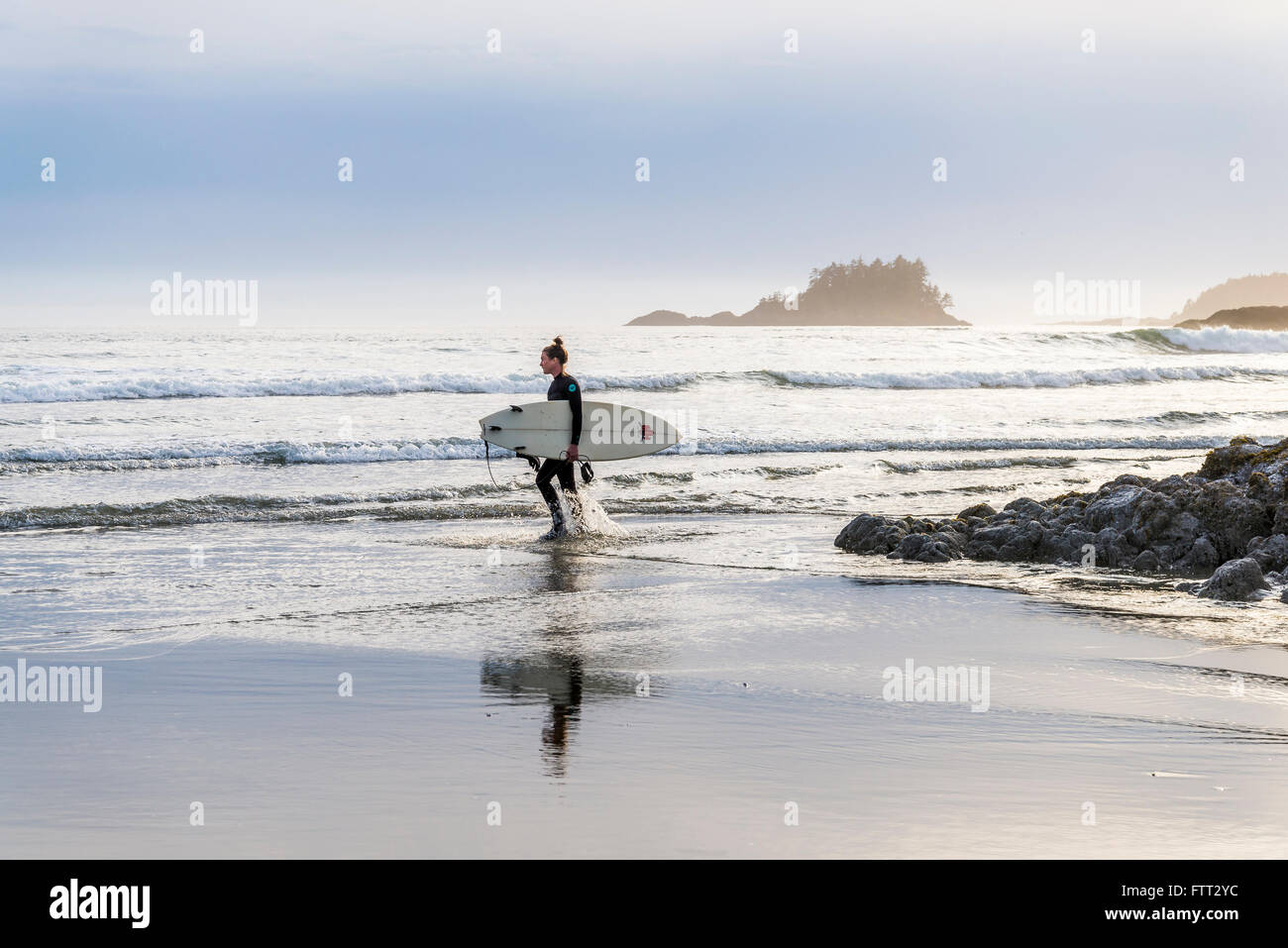 Young woman with surfboard, Chesterman Beach, Tofino, British Columbia, Canada Stock Photo