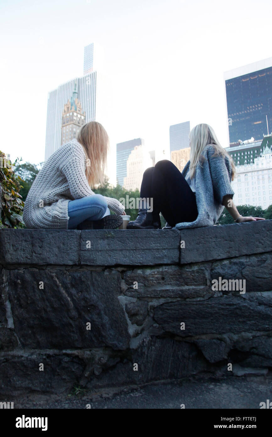 Two young women sitting in Central Park in the fall Stock Photo