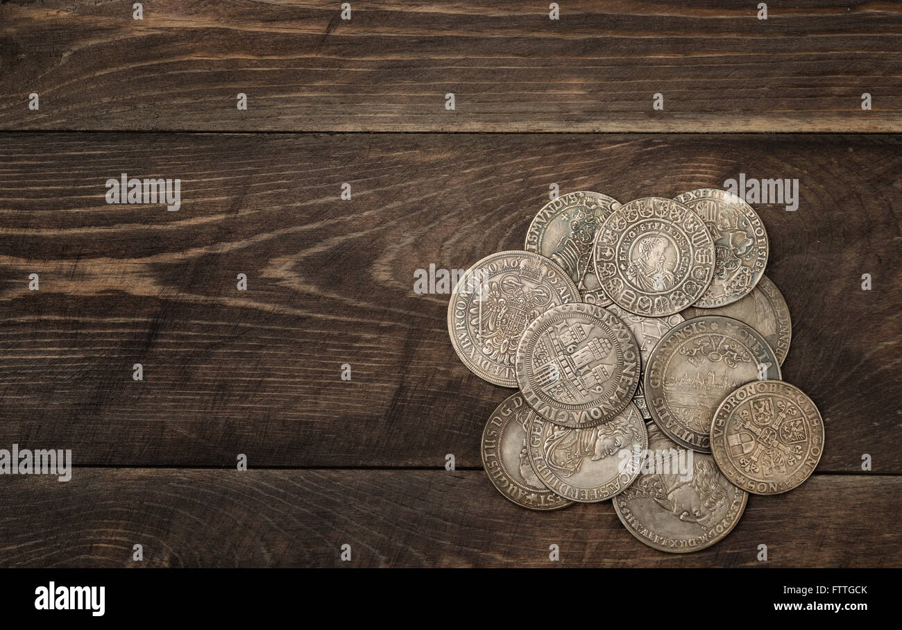 Ancient silver coins on dark wooden background Stock Photo