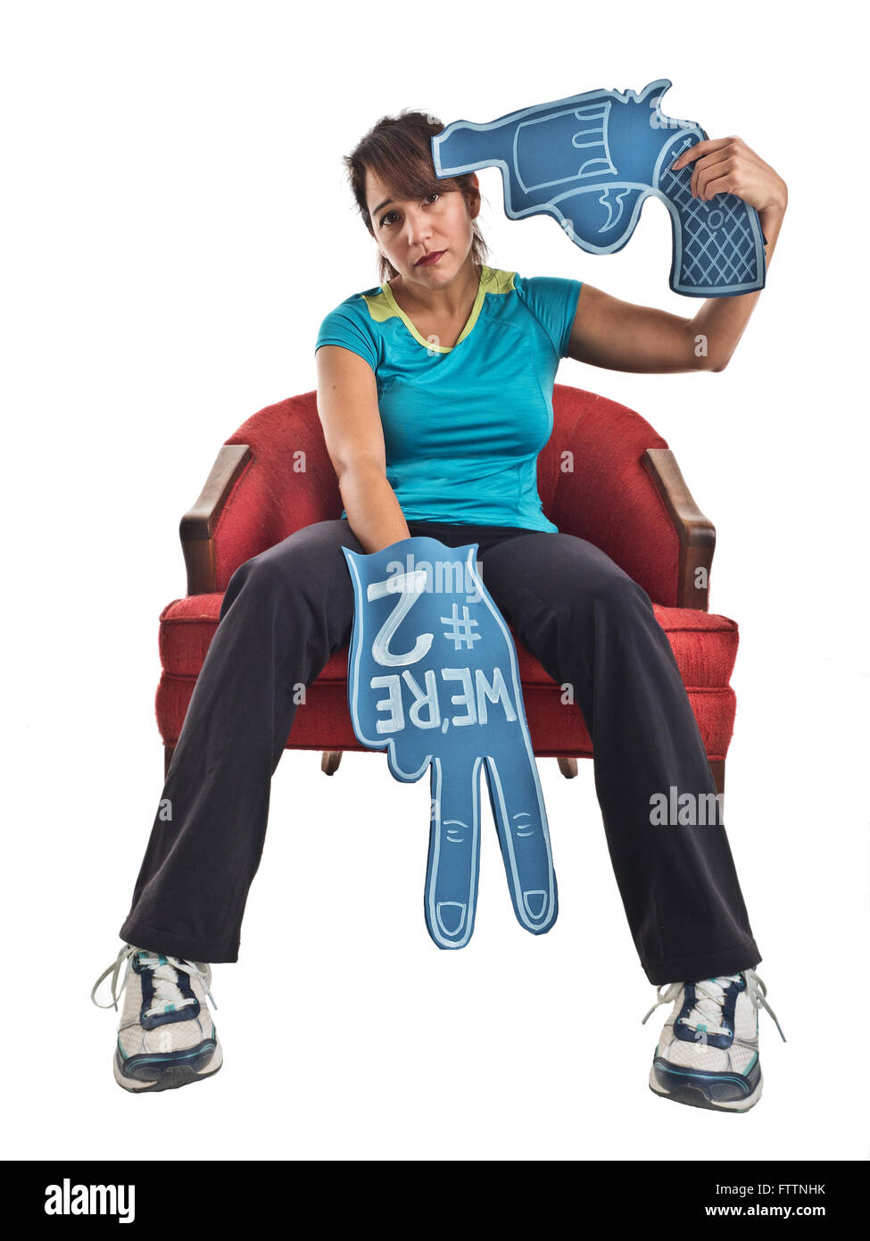 Humorous photograph of an adult female sports fan with a foam finger declaring 'We're #2.' The woman looks away from the camera  Stock Photo