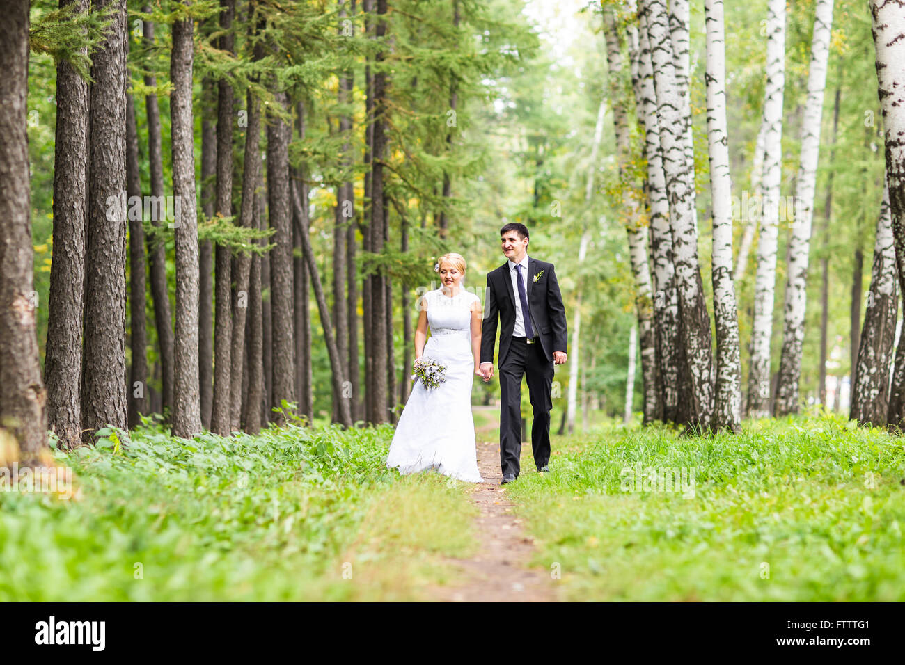 Bride and groom holding hands outdoors Stock Photo - Alamy