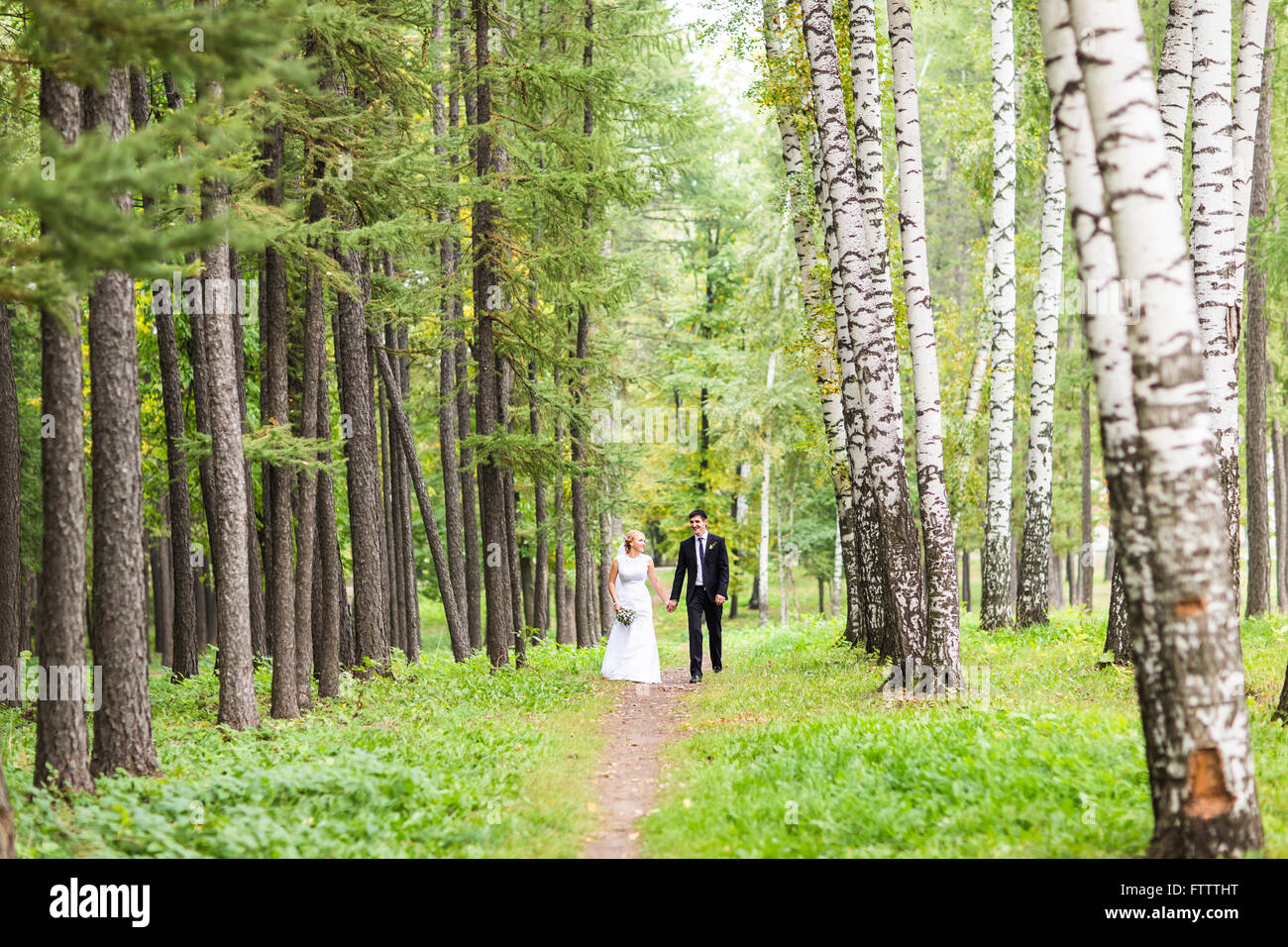 Bride and groom holding hands outdoors Stock Photo - Alamy