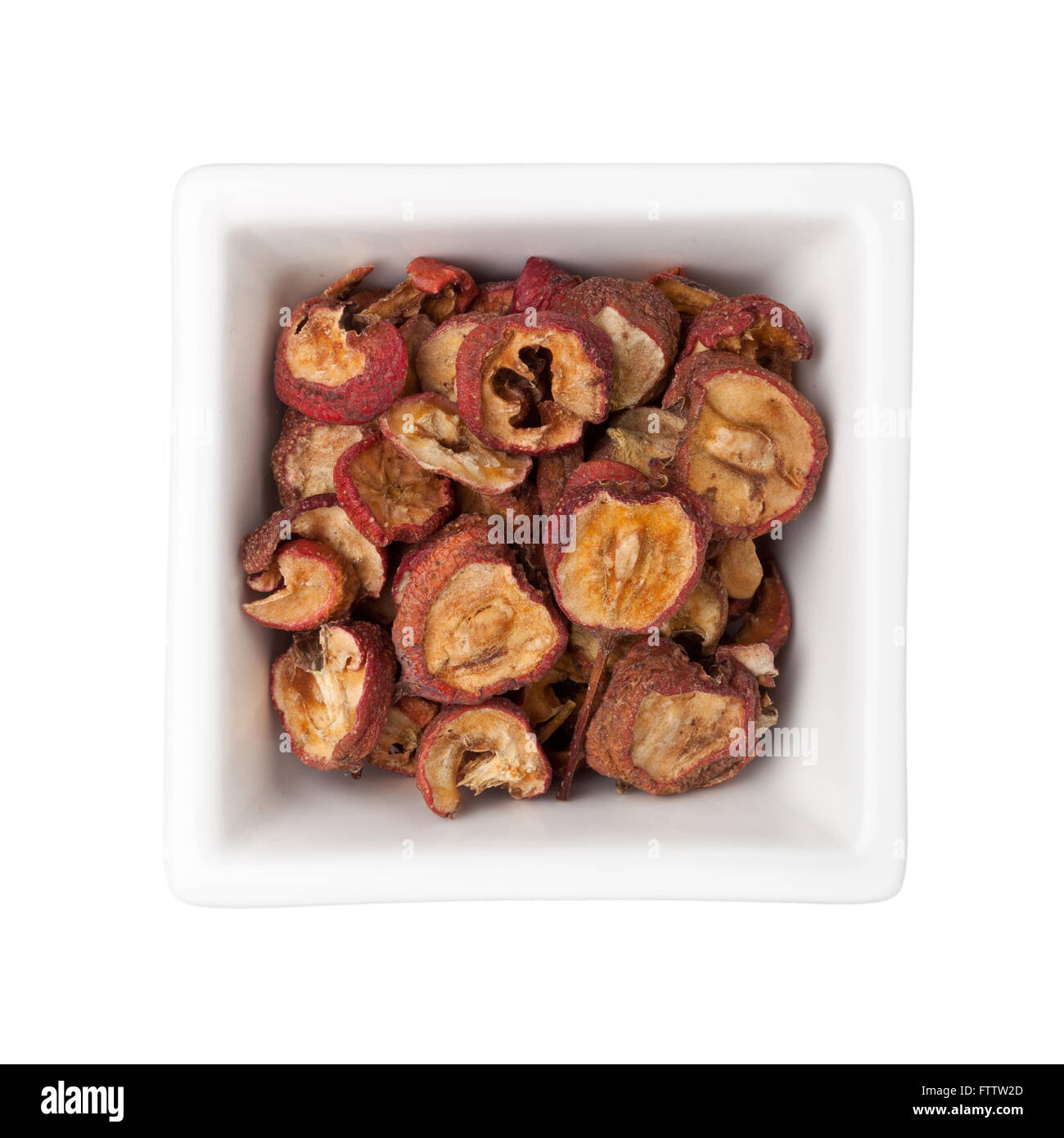 Dried hawthorn fruits in a square bowl isolated on white background Stock Photo