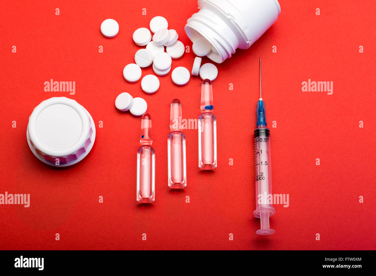 Disposable syringe for injection, ampoules, white round pills and pill bottles Stock Photo