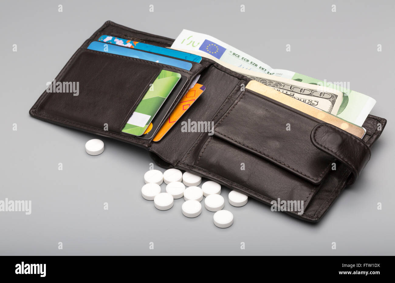 White round tablet and open leather wallet with banknote Stock Photo