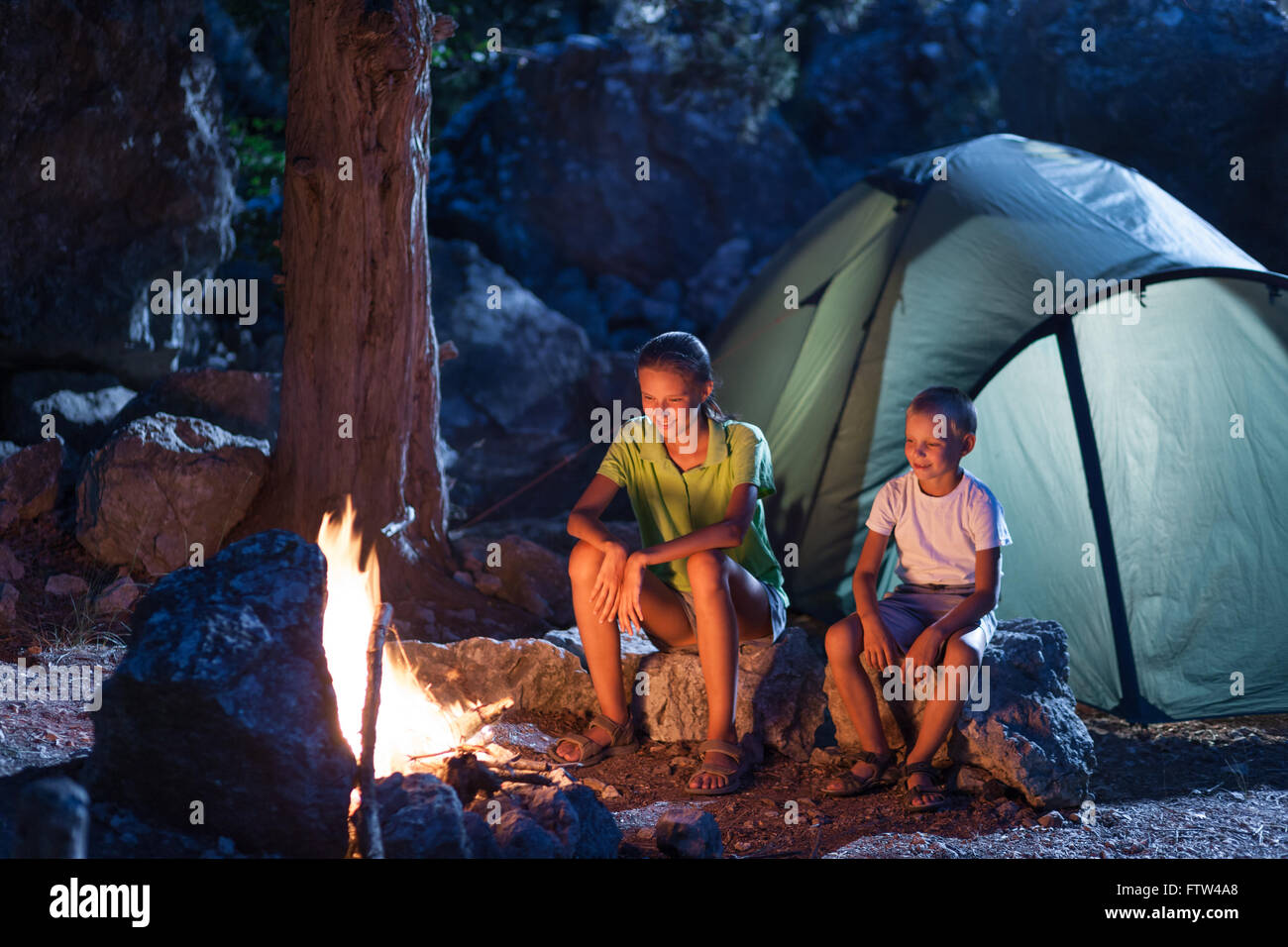 Sister with her brother at the camping at night Stock Photo
