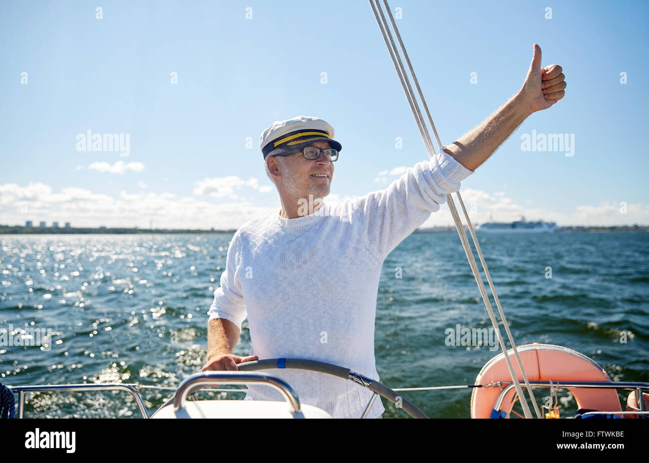 senior man at helm on boat or yacht sailing in sea Stock Photo - Alamy