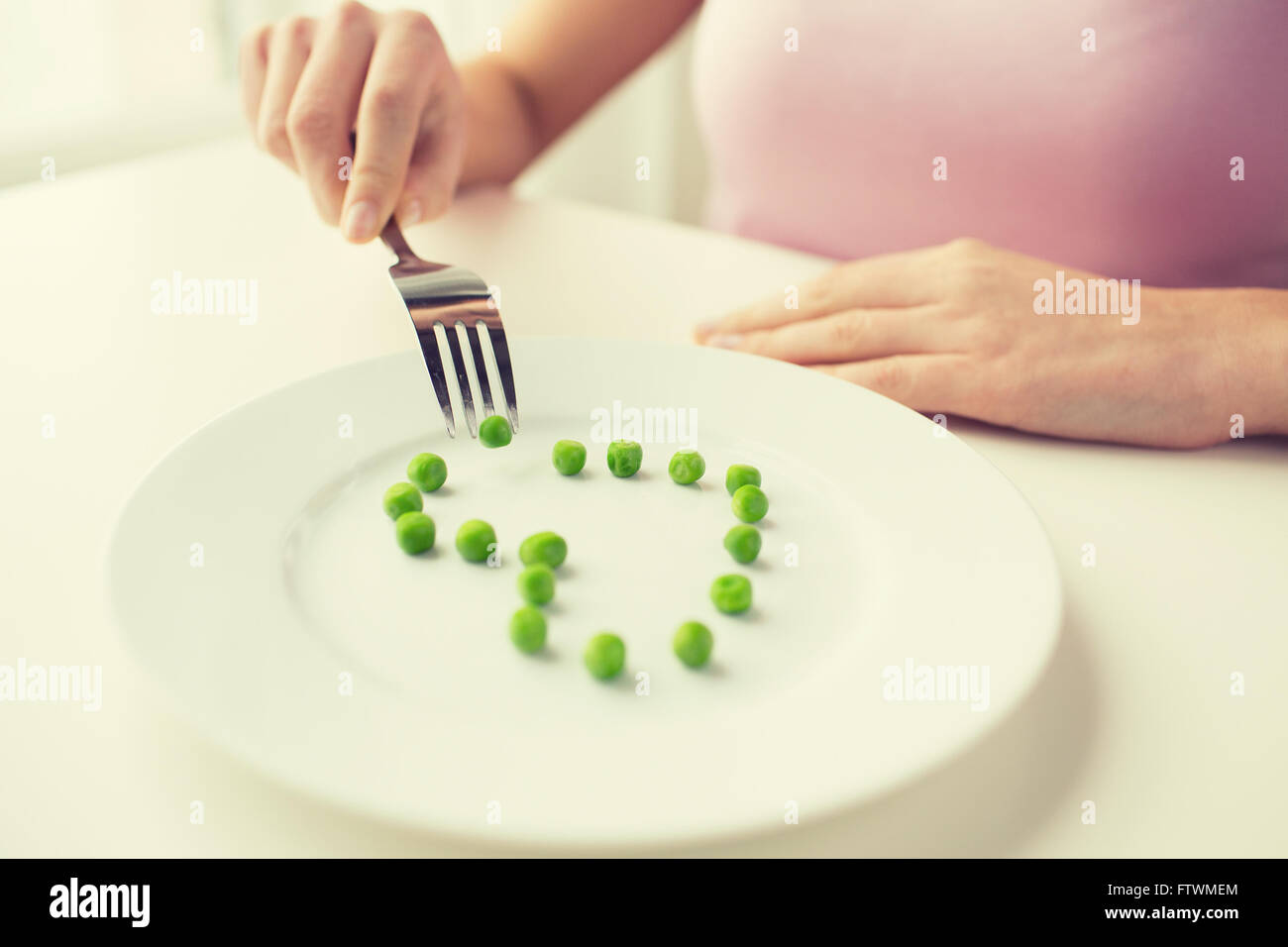 close up of woman with fork eating peas Stock Photo Alamy