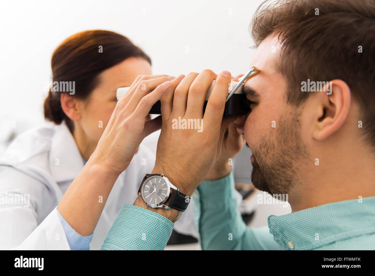 optician with pupillometer and patient at clinic Stock Photo
