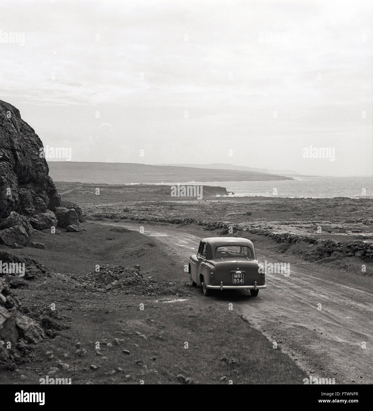 1950s historical, car parked on rough track by the Wild Atlantic coast, West of Ireland Stock Photo