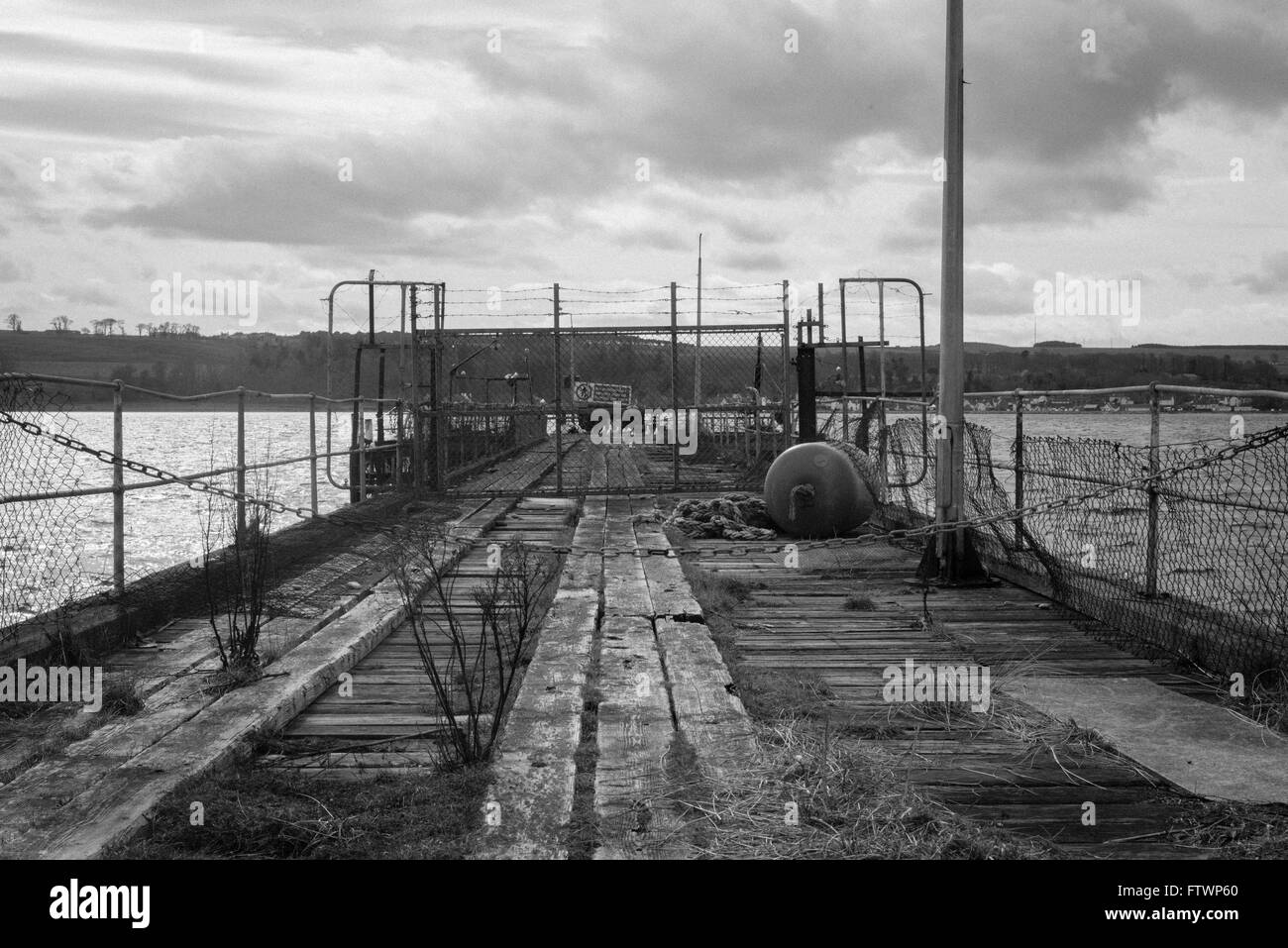 Old closed harbour jetty with wooden beams  and fencing near nigg Stock Photo