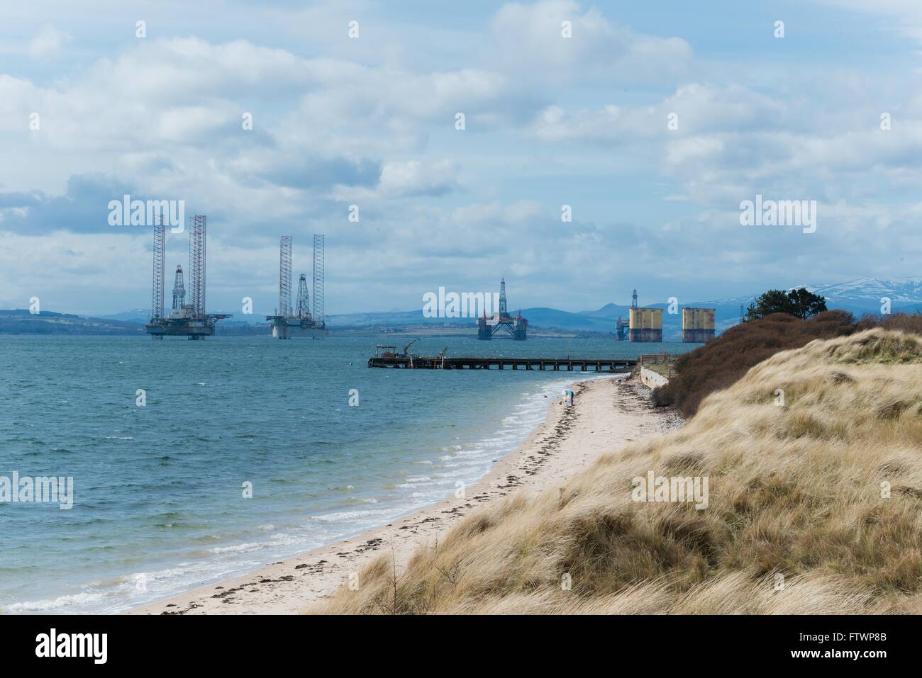 view of Cromarty Firth oil rigs from nigg beach Stock Photo