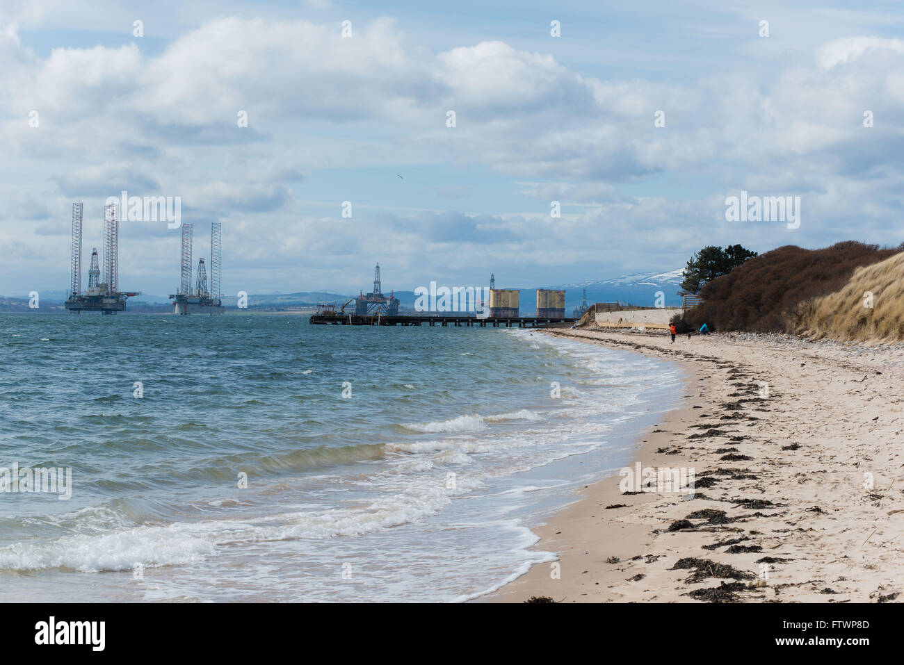 view of Cromarty Firth oil rigs from nigg beach Stock Photo